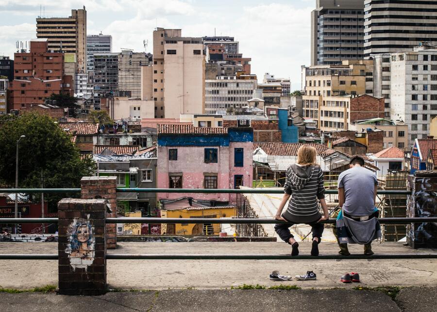 Two young people sitting on a railing in Bogota, Columbia