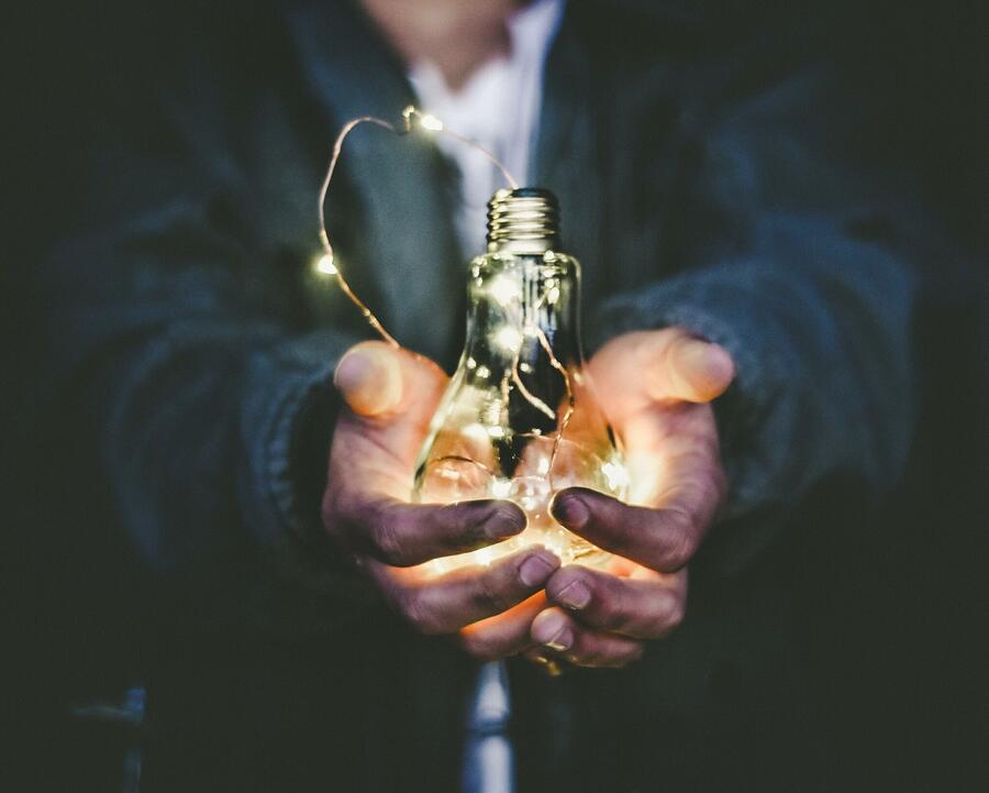 Man holding a glowing light bulb
